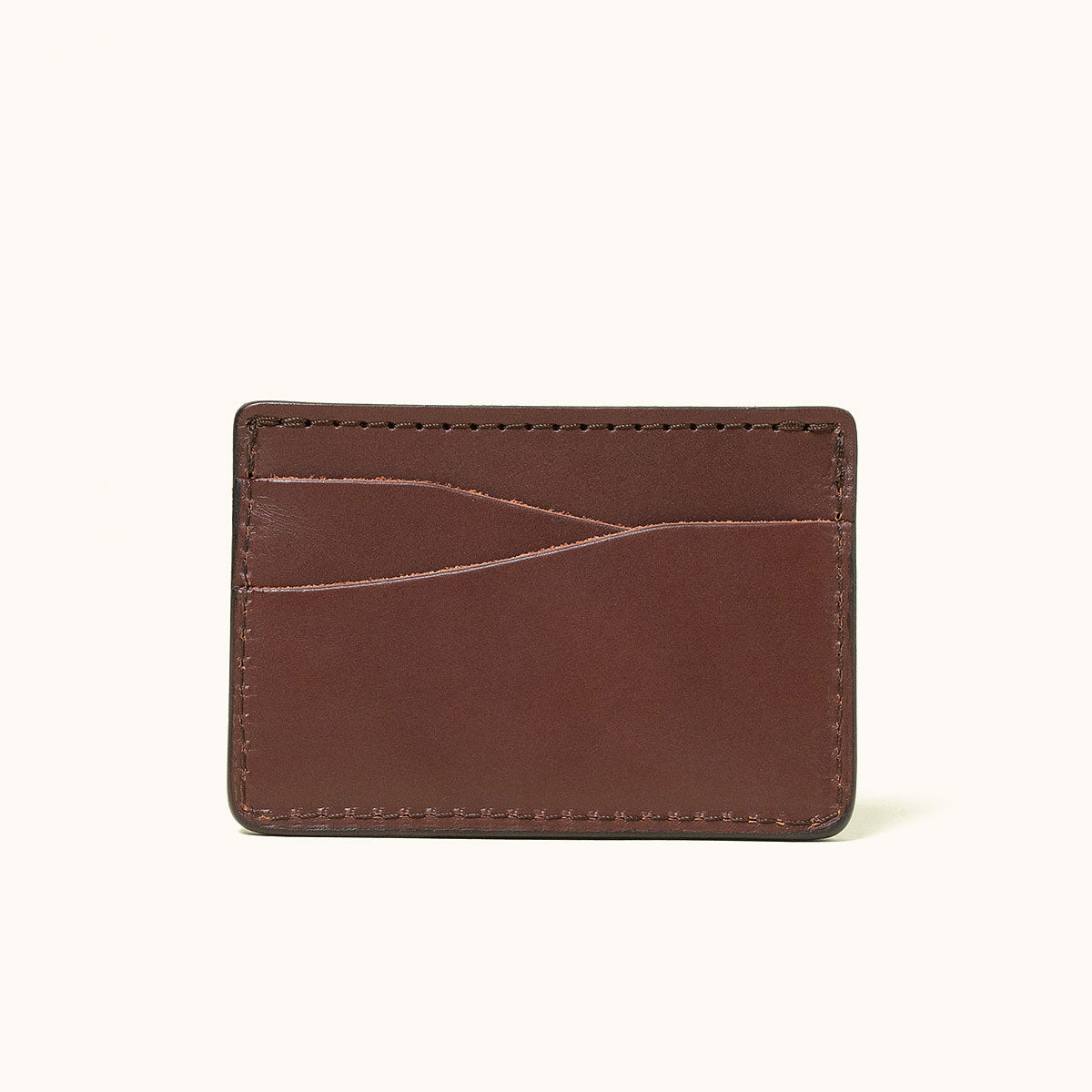 Cognac leather card holder wallet with multiple diagonal card slots and stitched edges.