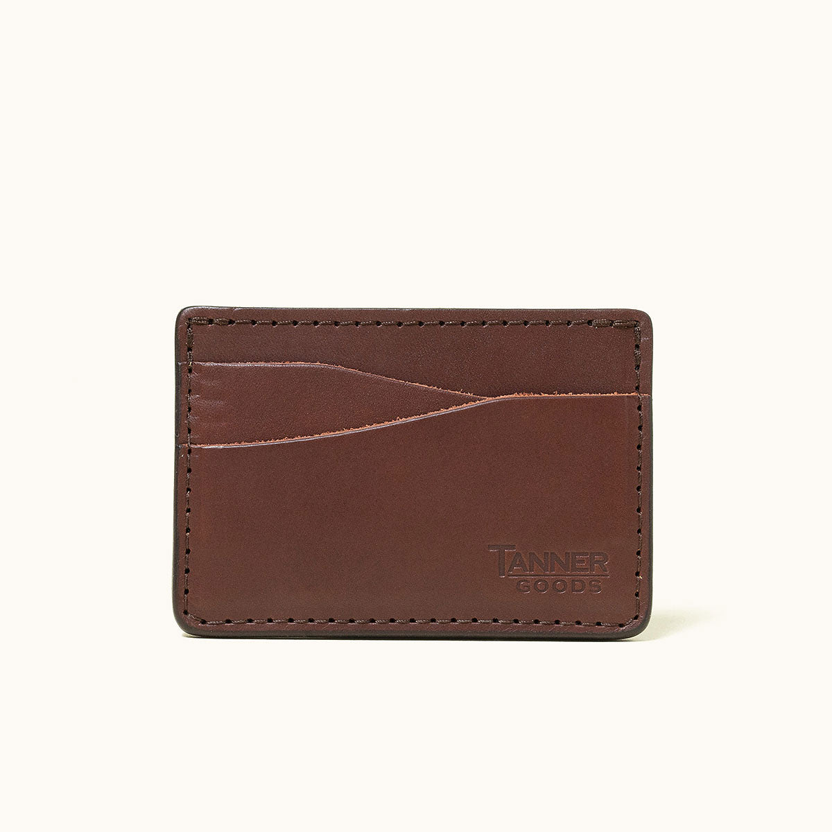Cognac leather wallet by Tanner Goods with multiple card slots, visible stitching, and embossed logo.