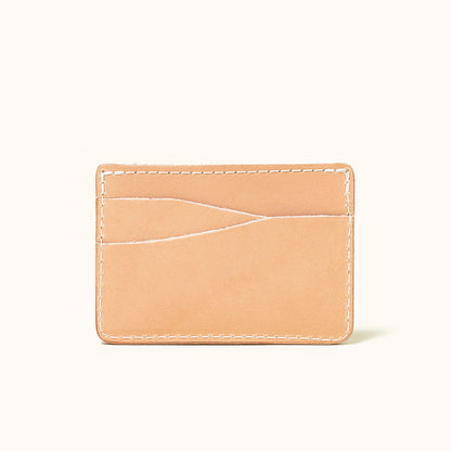 Natural leather wallet with two curved card slots and white stitching, shown front view.