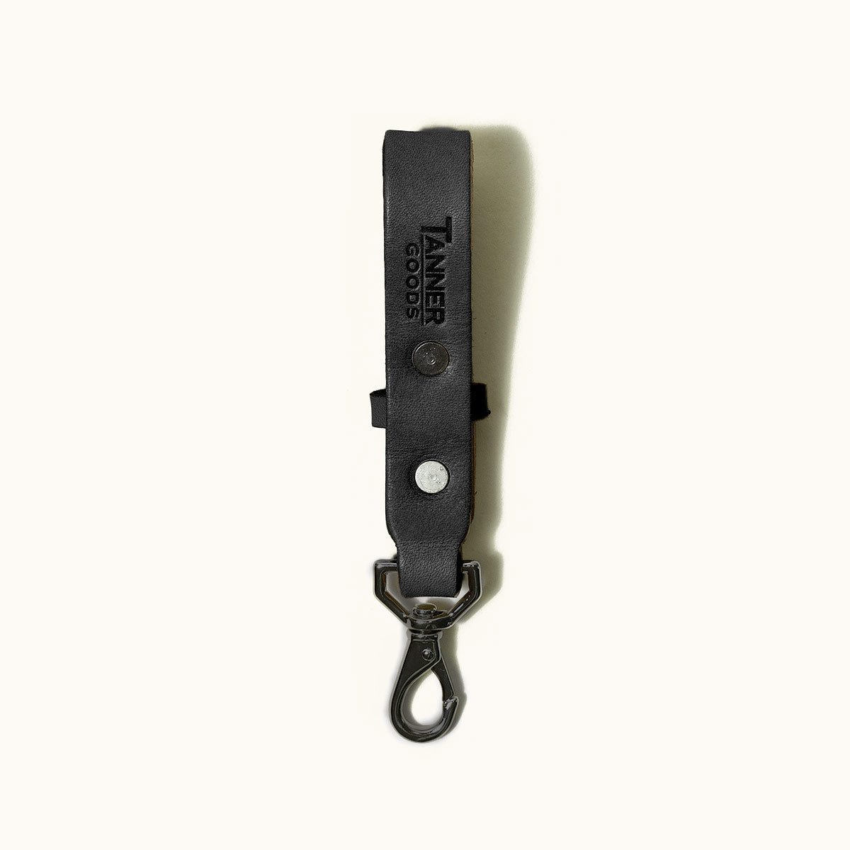 Black leather Key Lanyard with embossed 'TANNER GOODS' text, two metal snaps, and a dark metal swivel clasp.