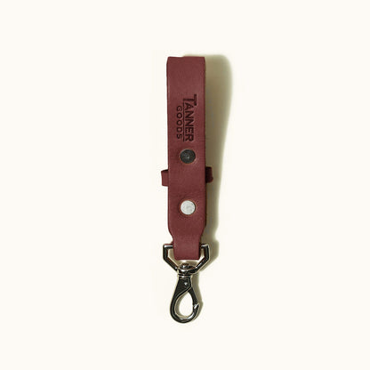 Cognac leather key lanyard with debossed 'TANNER GOODS' logo, silver rivets, and swivel clip.