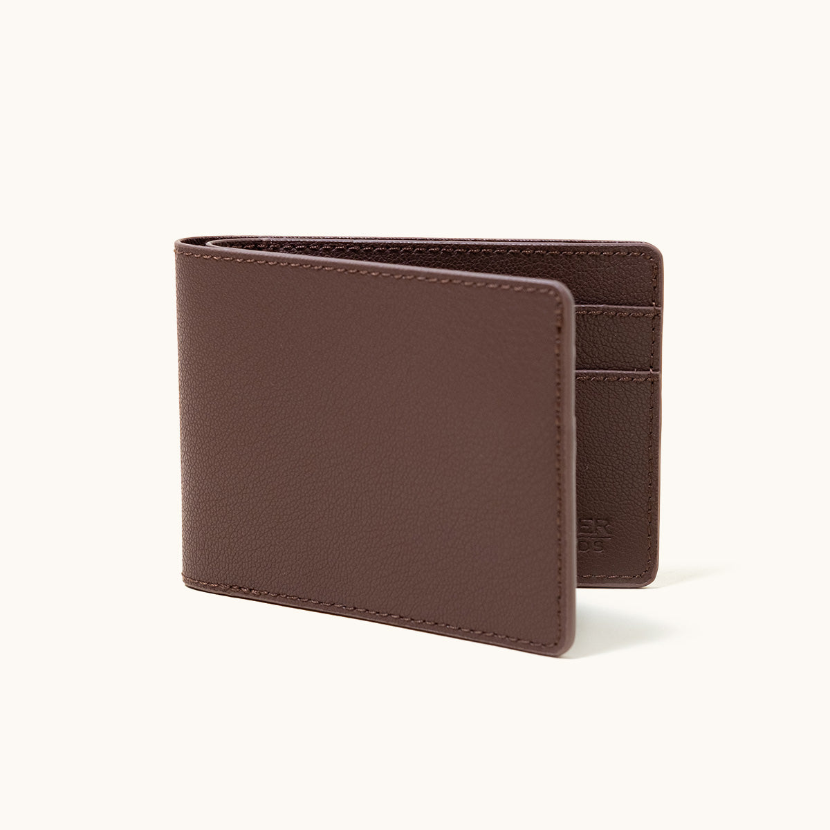 Cognac recycled leather bifold wallet, partially open, showing interior card slots and fine pebbled texture.