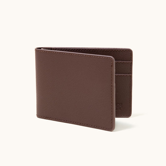 Cognac recycled leather bifold wallet, partially open, showing interior card slots and fine pebbled texture.