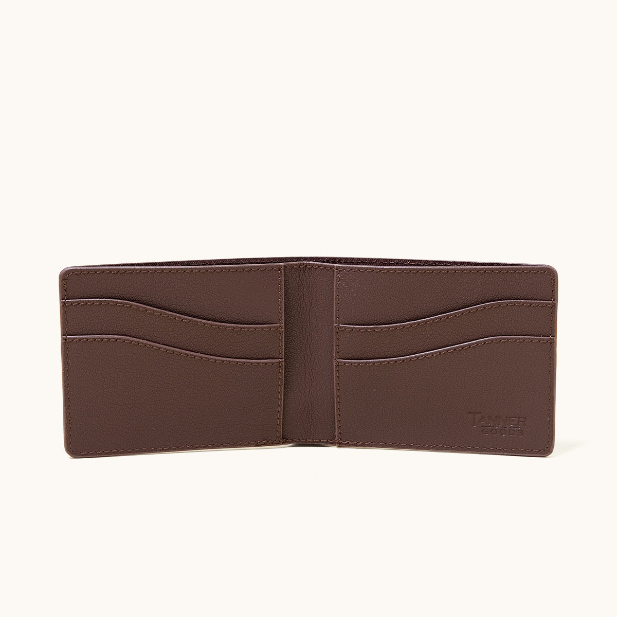 Cognac recycled leather utility bifold wallet, open to reveal multiple card slots and a bill compartment.
