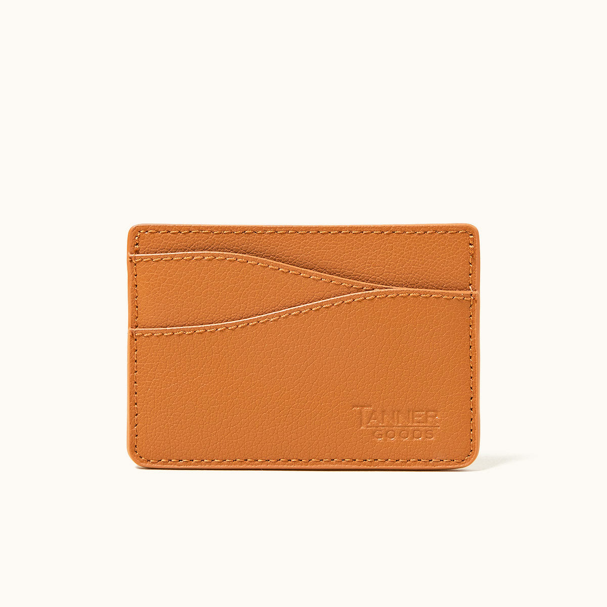 Saddle tan recycled leather card holder by Tanner Goods, featuring a pebbled texture, visible stitching, and multiple card slots.