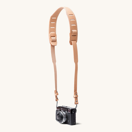 A silver and black SLR camera with a black leather strap.