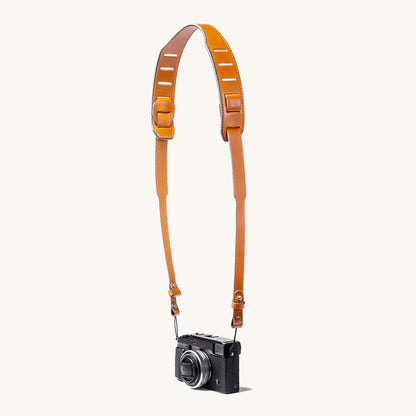 A silver and black SLR camera with a black leather strap.