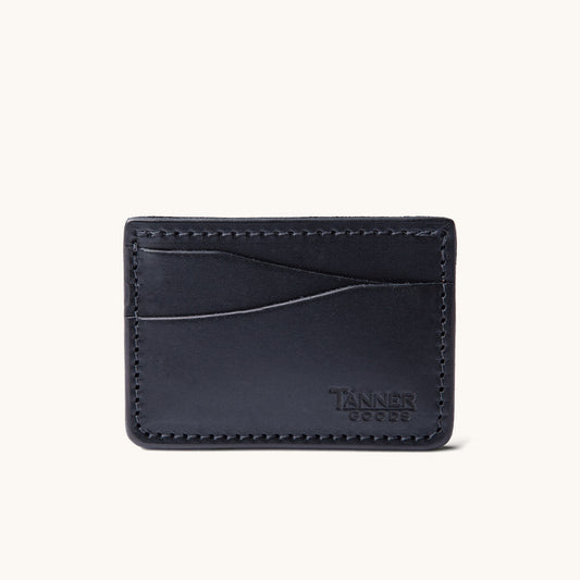 Black leather card wallet by Tanner Goods featuring two curved card slots and perimeter stitching.
