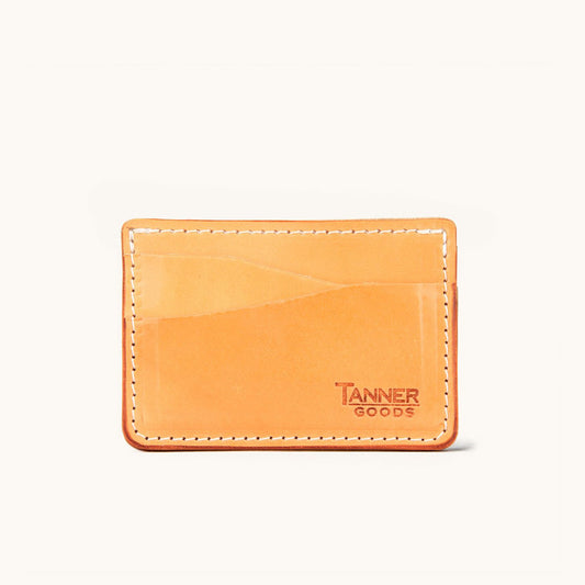 Golden leather card wallet by Tanner Goods with white stitching and multiple card slots.