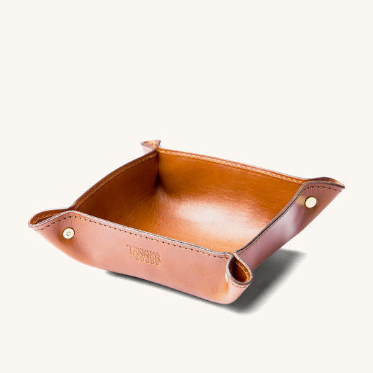 Saddle tan leather valet tray by Tanner Goods, with brass corner snaps and an embossed logo.